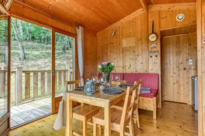 a dining room with a table and chairs in a cabin at Camping LA SERRE in Aigues-Vives