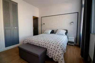 a bedroom with a bed with a large headboard at O'Bonheur de Hamma in Castelnaudary