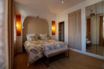 a bedroom with a bed with a bench in it at O'Bonheur de Hamma in Castelnaudary