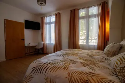 a bedroom with a bed and a desk and a window at O'Bonheur de Hamma in Castelnaudary