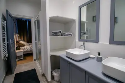a white bathroom with a sink and a mirror at O'Bonheur de Hamma in Castelnaudary