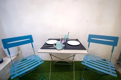 a table with two chairs and a table with two plates at Logis des Barques YourHostHelper in Narbonne