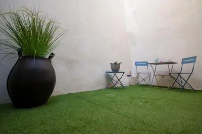 a large black vase with grass in a room with chairs at Logis des Barques YourHostHelper in Narbonne