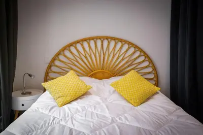 a bed with two yellow pillows on top of it at Logis des Barques YourHostHelper in Narbonne