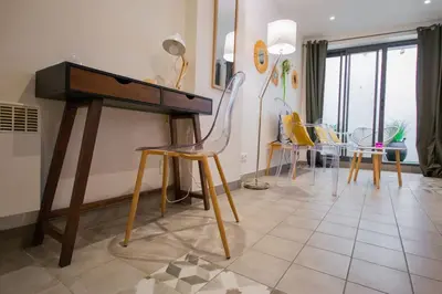 a room with a piano and chairs and a table at Logis des Barques YourHostHelper in Narbonne