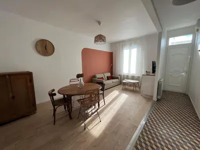 a living room with a table and a couch at La maison de Camille climatisation parking privé WIFI in Carcassonne