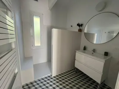 a white bathroom with a sink and a mirror at La maison de Camille climatisation parking privé WIFI in Carcassonne