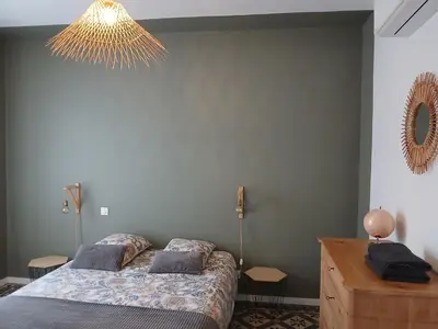 a bedroom with a bed and a chandelier at La maison de Camille climatisation parking privé WIFI in Carcassonne