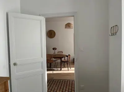 a door leading into a dining room with a table at La maison de Camille climatisation parking privé WIFI in Carcassonne