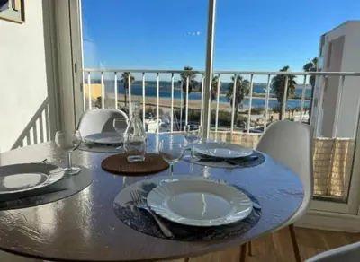a table with plates and wine glasses on a balcony at Appartement vue mer, plage à 20m in Gruissan