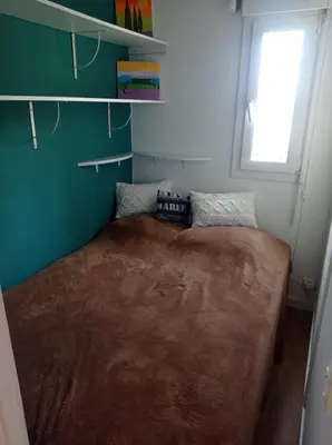 a large bed in a small room with a window at Appartement vue mer, plage à 20m in Gruissan