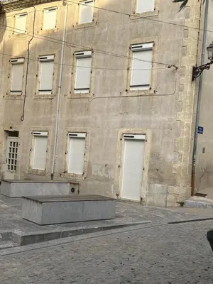 a building with white doors on the side of it at CHEZ COCO ET HERVE rez-de-chaussée in Sigean