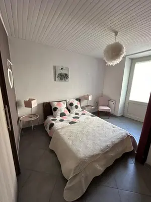 a bedroom with a large bed and two chairs at CHEZ COCO ET HERVE rez-de-chaussée in Sigean