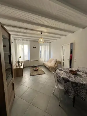 a living room with a table and a couch at CHEZ COCO ET HERVE rez-de-chaussée in Sigean