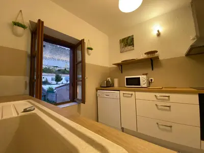 a kitchen with a bath tub and a microwave at Au pied de la cité, T3 au calme in Carcassonne