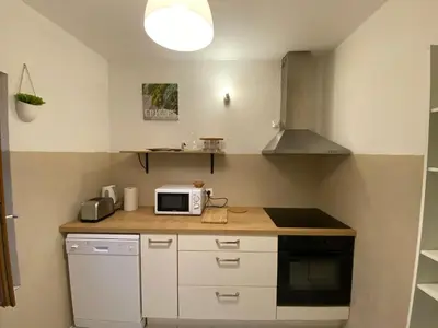 a kitchen with a counter top with a microwave at Au pied de la cité, T3 au calme in Carcassonne
