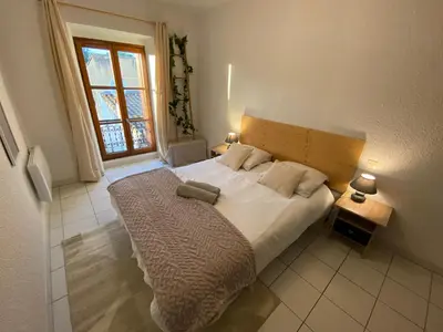 a bedroom with a bed and a window at Au pied de la cité, T3 au calme in Carcassonne