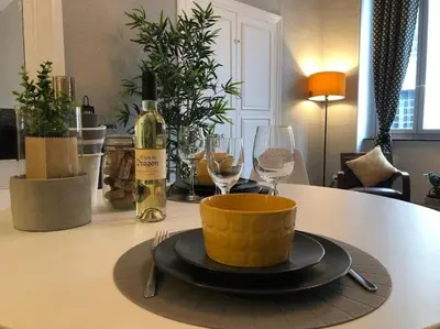 a table with a bottle of wine and two glasses at Studio au pied de la cité in Carcassonne