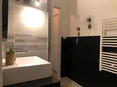 a bathroom with a white tub and a sink at Studio au pied de la cité in Carcassonne