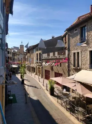 an empty street with tables and chairs and buildings at Studio au pied de la cité in Carcassonne