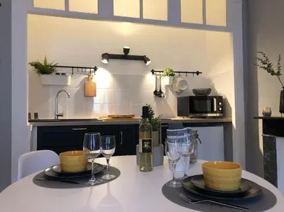 a kitchen with a table with glasses of wine at Studio au pied de la cité in Carcassonne