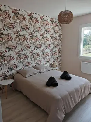 a bedroom with a bed with two black shoes on it at La Maison du Bagas, 7pers in Vielmur-sur-Agout
