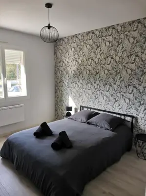 a bedroom with a large bed with a stone wall at La Maison du Bagas, 7pers in Vielmur-sur-Agout