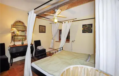 a bedroom with a bed with a ceiling fan and a piano at Nice Home In Ventenac-En-Minervois in Ventenac en Minervois