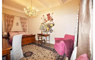 a bedroom with a bed and a chair and a chandelier at Nice Home In Ventenac-En-Minervois in Ventenac en Minervois