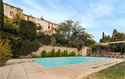 a swimming pool in a yard next to a building at Nice Home In Ventenac-En-Minervois in Ventenac en Minervois