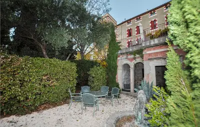 a patio with chairs and a table in front of a building at Nice Home In Ventenac-En-Minervois in Ventenac en Minervois