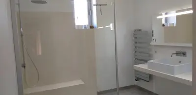 a white bathroom with a shower and a sink at Mas de la vigne in Montredon
