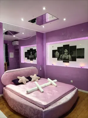 a purple bedroom with a bed with four baseball bats on it at L'instant Romance : Le glamour in Castelnaudary