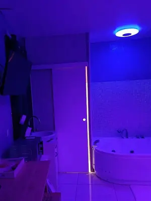 a bathroom with a white tub and a purple light at L'instant Romance : Le glamour in Castelnaudary