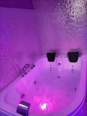 a bathroom with a tub with pink lights in it at L'instant Romance : Le glamour in Castelnaudary