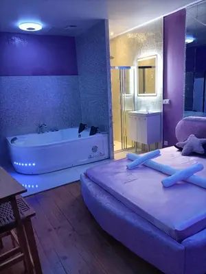 a bathroom with two beds and a bathtub and a bed and a tub at L'instant Romance : Le glamour in Castelnaudary