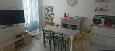 a kitchen with a table and chairs and a tv at Grand T3 calme et lumineux 4-6 personnes in Moux