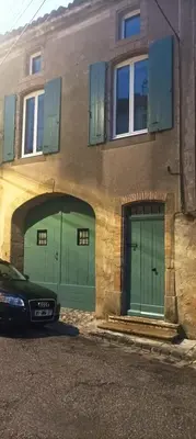 two green garage doors on the side of a building at Grand T3 calme et lumineux 4-6 personnes in Moux