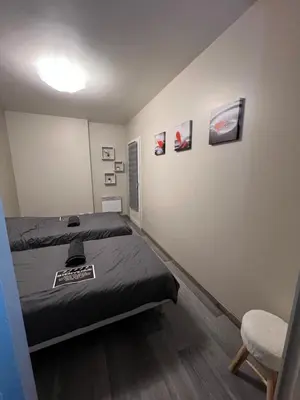 a bedroom with a bed and a chair in it at Plumes Résidence de l’Agout in Castres
