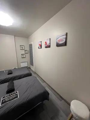 a bedroom with a bed and a chair and pictures on the wall at Plumes Résidence de l’Agout in Castres
