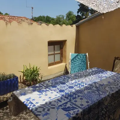 a patio with two chairs and a table and a window at Petite maison de designer (avec terrasse) in Durban-Corbières