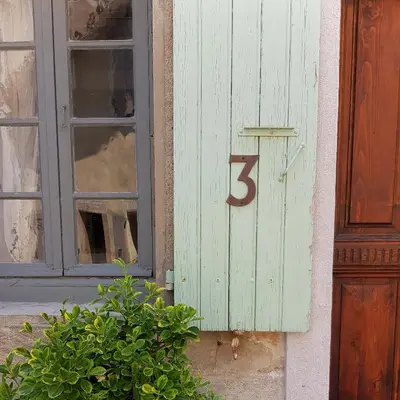 a number on the side of a building with a window at Petite maison de designer (avec terrasse) in Durban-Corbières
