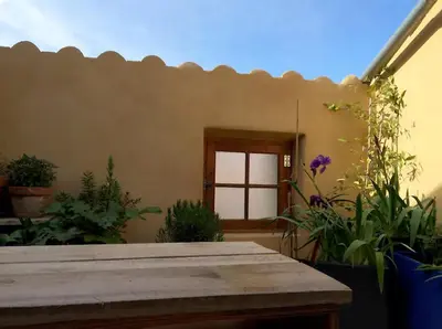 a patio with a wooden table and some plants at Petite maison de designer (avec terrasse) in Durban-Corbières