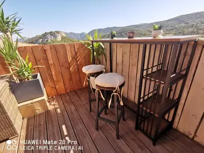 a balcony with a bar and two stools at L'ÉTAPE BIEN ÊTRE,chambres et tables d'hôtes, salon de massage in Camps-sur-lʼAgly
