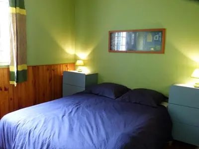 a bedroom with a bed with blue sheets and a mirror at Chalet with garden in the Pyrenees in Roquefort-de-Sault