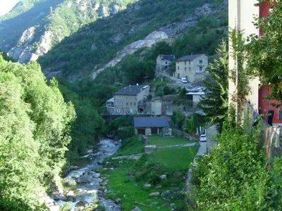 a village with a river in the middle of a mountain at Chalet with garden in the Pyrenees in Roquefort-de-Sault