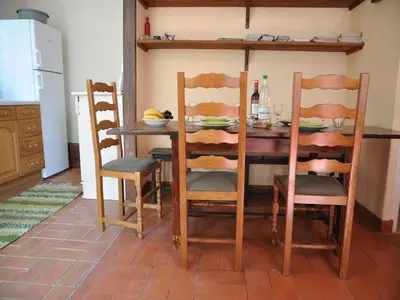 a dining room table with four chairs and a table with at Chalet with garden in the Pyrenees in Roquefort-de-Sault