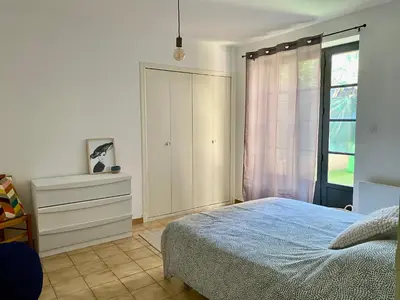 a bedroom with a bed and a dresser and a window at Confortable T2 avec jardin aménagé in Lézignan-Corbières