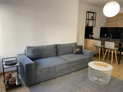 a living room with a couch and a table at Confortable T2 avec jardin aménagé in Lézignan-Corbières