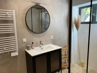 a bathroom with a sink and a mirror at Confortable T2 avec jardin aménagé in Lézignan-Corbières